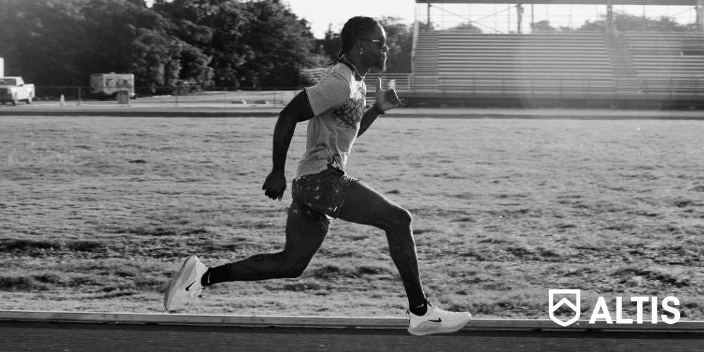 An athlete in full stride running on a track, showcasing determination and speed, with the focus on their form and the track beneath their feet.